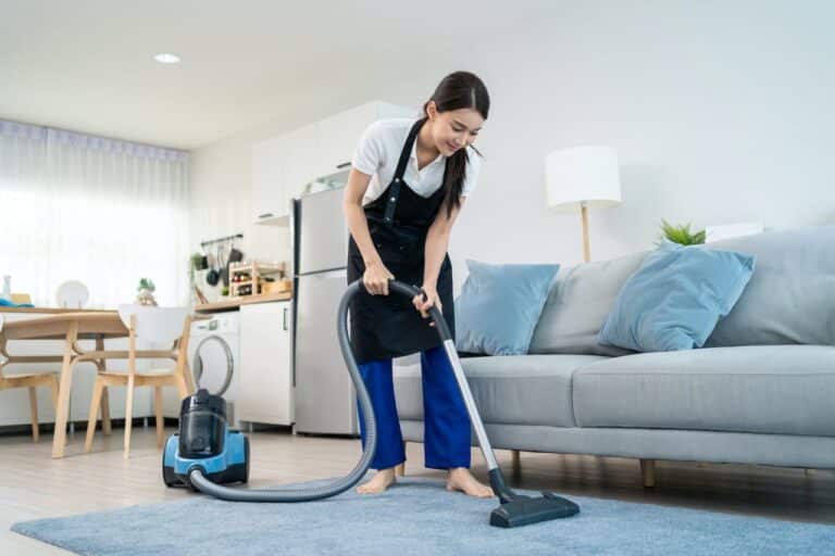 asian cleaning service woman worker cleaning in living room at home